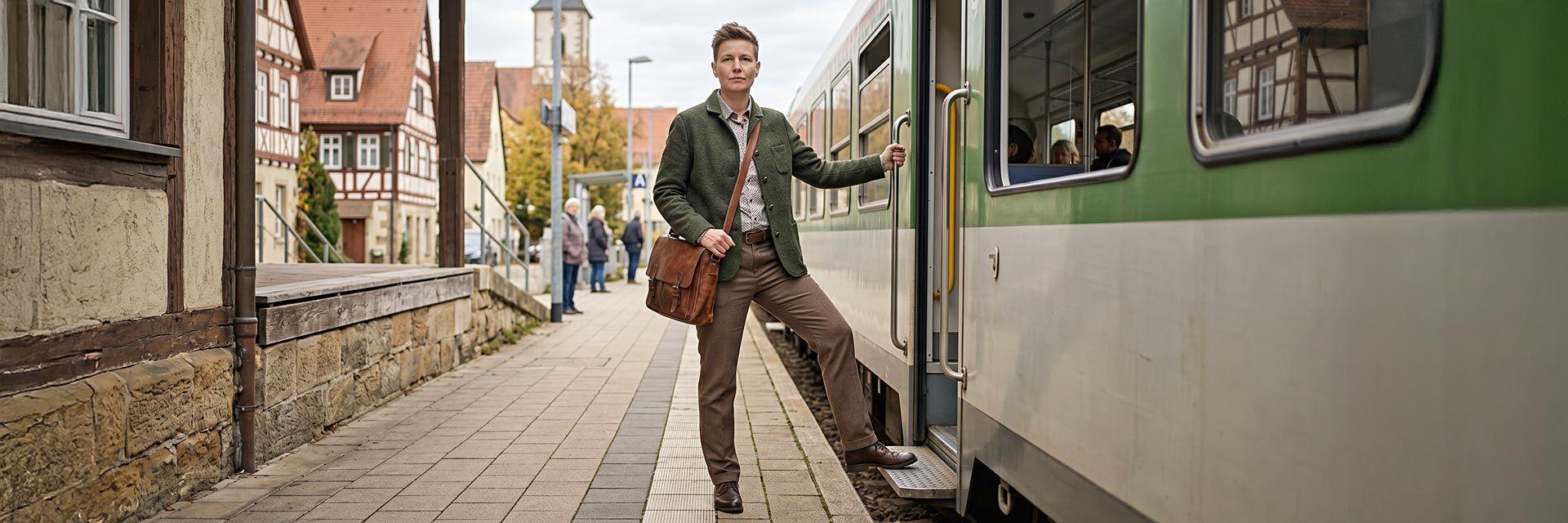 Frau steigt am Bahnhof in einen Zug ein, Quereinstieg in ein neues Berufsfeld